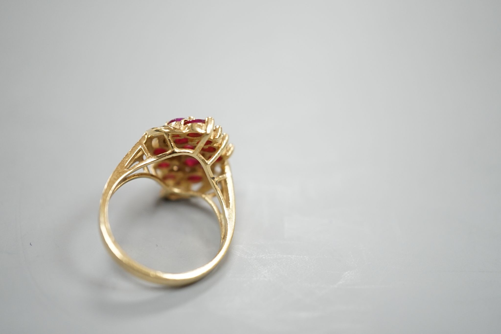 A modern 14k yellow metal ,ruby and diamond cluster set dress ring, size M, gross weight 5 grams.